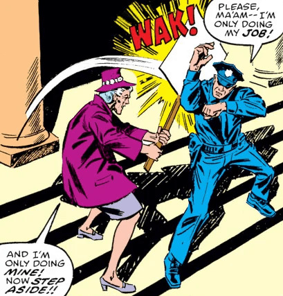 Spider-Man character Aunt May whacks a policeman with a protest sign. The cop says “please, ma’am— I’m only doing my job!” Aunt May says, “and I’m only doing mine! Now step aside!”