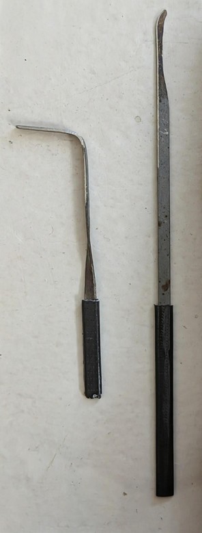 An L-shaped turning tool and a medium-hook lockpick, fashioned from two street sweeper bristles, with their handles wrapped in a bit of black electrical tape.